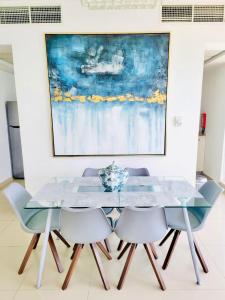 a dining room with a glass table and chairs at Luxurious 2 bedroom Beachfront Apartment - direct seaview in Ras al Khaimah