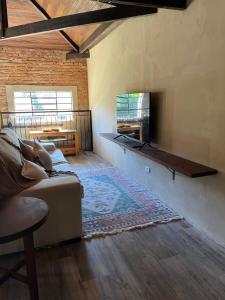 uma sala de estar com um sofá e uma televisão em Vila Adega Maravilha em São Roque