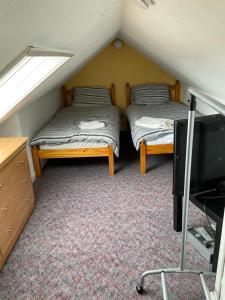 um quarto com duas camas e uma televisão num sótão em Gables Seaview 4 school Str Largs top floor em Largs