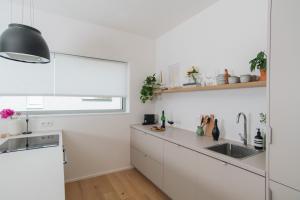 uma cozinha com armários brancos e um lavatório em Apartments Marinka Litomyšl em Litomyšl