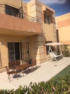 eine Terrasse mit 2 Stühlen und einem Tisch vor einem Gebäude in der Unterkunft New venecia resort in Ain Suchna