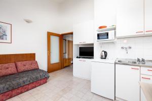 a living room with a couch and a kitchen at Apartments Mrak in Punat