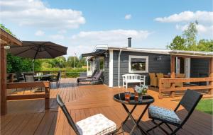 a deck with a tiny house with a table and chairs at Stunning Home In Jgerspris With Kitchen in Jægerspris
