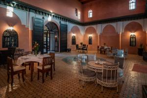 a restaurant with tables and chairs in a room at Riad Al Riadinou in Aghmat