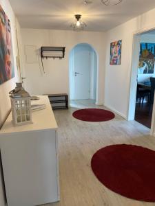 a living room with red rugs on the floor at Ferienwohnung Baumgartner Chiemseeliebe 2OG in Breitbrunn am Chiemsee +4 photos