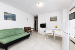 Apartments Mrak في بونات: غرفة معيشة مع أريكة خضراء وطاولة