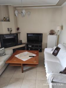 a living room with a couch and a coffee table at ANNASHOUSE in Nea Peramos