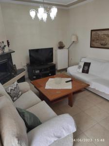 een woonkamer met een bank en een salontafel bij ANNASHOUSE in Néa Péramos
