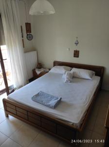 a bedroom with a large bed with white sheets at ANNASHOUSE in Nea Peramos