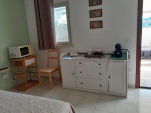 ein Schlafzimmer mit einer weißen Kommode und einer Mikrowelle in der Unterkunft El Paso in Castro di Lecce