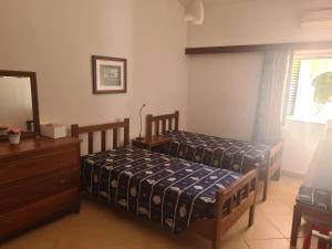 1 dormitorio con 2 camas, tocador y espejo en Vilamoura Alecrim, en Vilamoura