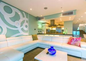 a living room with a white couch and a table at Pearls of Umhlanga Multi-Story Penthouse in Durban