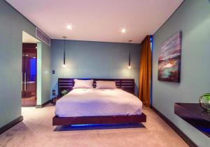 a bedroom with a bed and a blue wall at Pearls of Umhlanga Multi-Story Penthouse in Durban