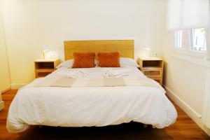 1 dormitorio con 1 cama blanca grande y 2 mesitas de noche en TALABERRI, en Bermeo