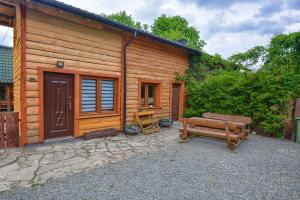 a wooden cabin with a bench in front of it at Noclegi u Kanara in Lutowiska