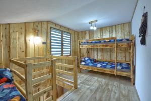 2 łóżka piętrowe w pokoju z drewnianymi ścianami w obiekcie Noclegi u Kanara w mieście Lutowiska