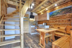 a log cabin kitchen and dining room with a ladder and a table at Noclegi u Kanara in Lutowiska