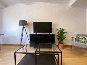 sala de estar con TV y mesa de centro de cristal. en Executive STYLE near DownTwon en Valencia