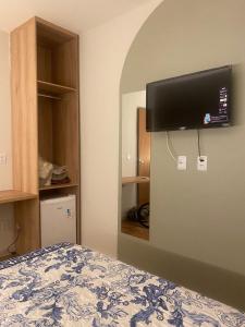 a bedroom with a bed with a flat screen tv on the wall at Hotel Casa Blanca in Mossoró +23 photos