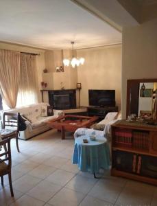 a living room with a couch and a table at ANNASHOUSE in Nea Peramos