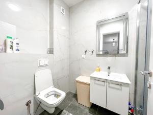 La salle de bains blanche est pourvue de toilettes et d'un lavabo. dans l'établissement Happy Home, à Ulcinj