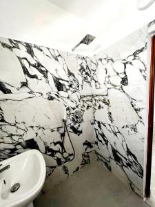 a bathroom with a black and white marble wall at Vila Manuel in Shëngjin