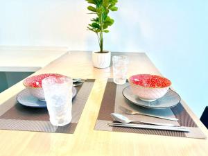 a table with two bowls and plates on a table at R 1-5Pax Cozy Home SetiaAlam 100mpsWifi&TV Trefoil in Setia Alam