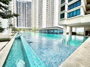 a large swimming pool in a building with tall buildings at R 1-5Pax Cozy Home SetiaAlam 100mpsWifi&TV Trefoil in Setia Alam