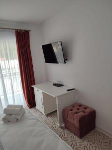 Zimmer mit einem Schreibtisch, einem Stuhl und einem TV in der Unterkunft Casa Anne in Băile Herculane