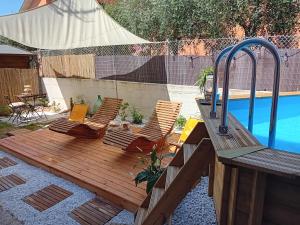 una terraza de madera con sillas junto a una piscina en B&B Tra colline marchigiane - sauna e piscina en San Giorgio di Pesaro