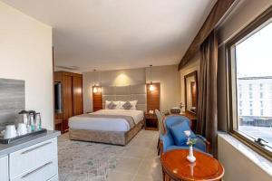 Un dormitorio con una cama, una mesa y una silla. en Rose ALMedina روز المدينة, en Medina