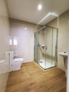 a bathroom with a shower and a toilet and a sink at BAHíA APARTAMENTOS TURÍSTICOS in Foz