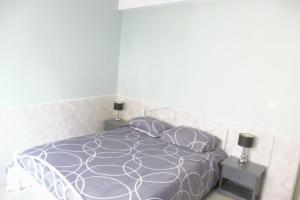 sypialnia z fioletowym łóżkiem i 2 szafkami nocnymi w obiekcie F4 VERNET LES BAINS w mieście Vernet-les-Bains