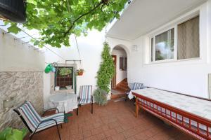 een patio met een bank en stoelen en een raam bij Apartment Rimanic in Zadar