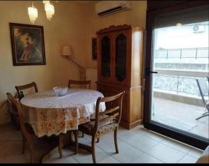 een eetkamer met een tafel en stoelen en een raam bij ANNASHOUSE in Néa Péramos