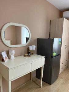 een kamer met een bureau, een koelkast en een spiegel bij MIQT GUEST HOUSE in Shkodër