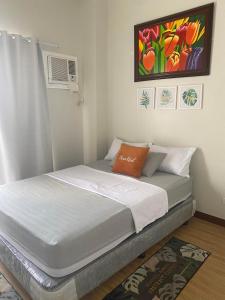 a bed in a bedroom with a painting on the wall at VERDON PARC CONDOMINIUM in Davao City