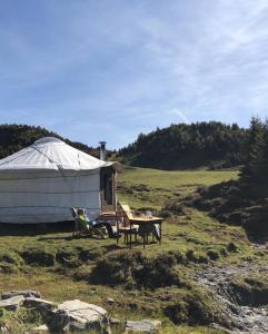 una yurta con tavolo e sedie in un campo di Alp Jurte Skihütte Feldis a Feldis