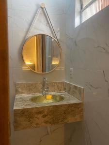 a bathroom with a sink and a mirror at Hotel Casa Blanca in Mossoró