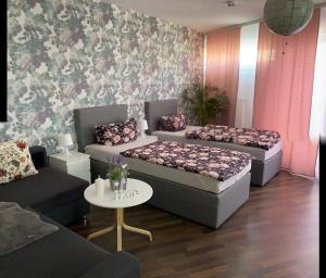 een woonkamer met 2 bedden en een tafel bij RoseMarie in Gotha