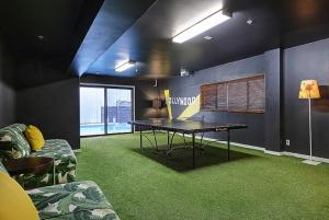 a ping pong table in a room with green carpet at Shelter Hotel Los Angeles in Los Angeles