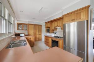 a kitchen with wooden cabinets and a stainless steel refrigerator at Southern Ocean Retreat in Warrnambool