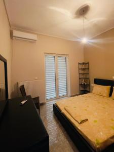 een slaapkamer met een bed, een tafel en een raam bij Luxury seaside apartment, 3 bedrooms in Livanátai