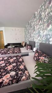 Zimmer mit 2 Betten und einer Wand mit Blumen in der Unterkunft RoseMarie in Gotha