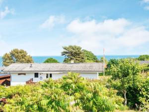 a white house with the ocean in the background at Holiday home Augustenborg VI in Augustenborg