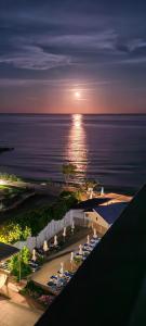 eine Gruppe von Menschen, die bei Sonnenuntergang am Strand in Stühlen sitzen in der Unterkunft Moonlight Hotel - All Inclusive in Sweti Wlas