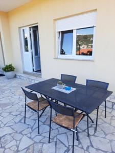 a black table and chairs on a patio at MaroVito in Supetarska Draga