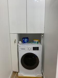 a washing machine in a room with white cabinets at Garden Apartament - Self Check-In - wejdź już teraz in Krakow