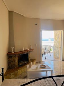 een woonkamer met een open haard en een tafel bij Luxury seaside apartment, 3 bedrooms in Livanátai