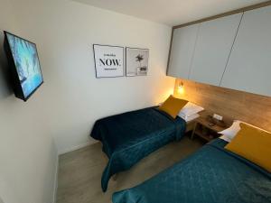 a hotel room with two beds and a tv at Mobile home Mare Blu in Rovanjska